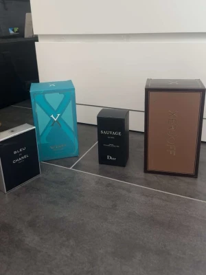 Fyra exklusiva parfymboxar - Säljer fyra lyxiga parfymboxar: Bleu de Chanel i mörkblå förpackning, Xerjoff i brun och turkos box samt Dior Sauvage i svart. Alla boxar har elegant design och tydliga logotyper. Perfekt för dig som gillar exklusiva dofter och snygga förpackningar. 350kr st