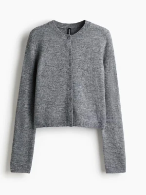 Grå cropped kofta med knappar - Mysig grå cropped kofta med rund hals och knäppning framtill. Tillverkad i mjukt stickat material och har långa ärmar. Perfekt att styla över ett linne eller t-shirt för en avslappnad look.