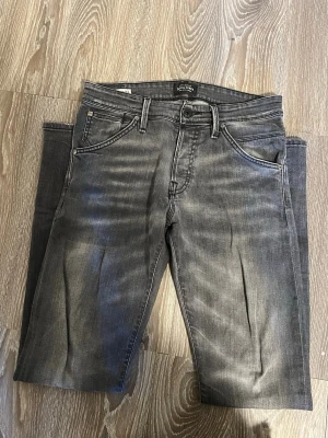 Gråa slim fit jeans från Weekday - Säljer ett par gråa slim fit jeans från Weekday med snygg tvättad look och klassiska fem fickor. Jeansen har normal midja, bälteshällor och dragkedjegylf. Perfekta för en avslappnad och trendig stil.Skriv för fler frågor och bilder