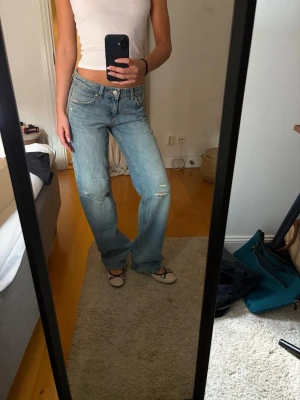 Ljusblå raka jeans med slitningar - Säljer ett par ljusblå jeans med raka ben och slitna detaljer på knä och lår. Säljer pga dom inte används💛