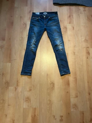 Dondup jeans - Snygga dondup jeans med slitningar på låren och knäna. Jeansen har klassisk femficksdesign, låg midja och smal passform. Perfekta för en avslappnad och trendig look. Materialet är troligtvis bomull med lite stretch för extra komfort.