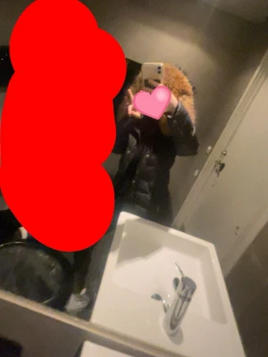 Svart dunjacka med pälskantad huva - Säljer en svart dunjacka med fluffig pälskantad huva. Jackan är lång, har quiltad design och ger en riktigt varm känsla. Perfekt för kalla vinterdagar och har en stilren look som passar till det mesta.