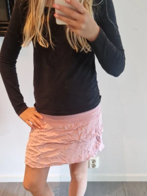 Rosa kortkjol, lager 157 - Söt rosa kortkjol från lager 157 med bred resår i midjan för skön passform. Passar till både t-shirt och stickad tröja. Dock litr skrynklig.