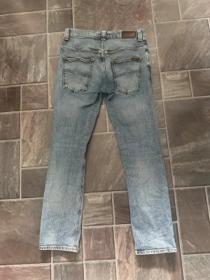 Ljusblå nudie jeans - Säljer mina nudie jeans i storlek W32 L30. Dom har blivit för små för mig men annars så har dem varit riktigt bra. 