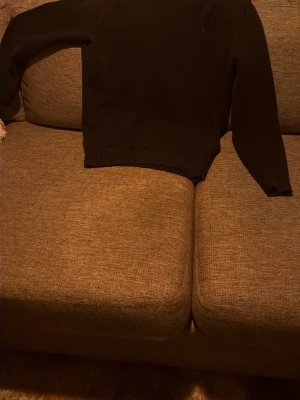 Svart stickad tröja Polo Ralph Lauren - Klassisk mörkblå stickad tröja från Polo Ralph Lauren med rund halsringning och diskret broderad logga på bröstet. Tröjan har ribbade muddar vid ärmslut och nederkant. Storlek xs men passar även M