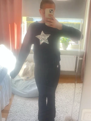 Marinblå tröja med paljettstjärna - Cool marinblå tröja med en stor silverfärgad paljettstjärna på bröstet. Tröjan har rund halsringning och långa ärmar. Mjuk och bekväm att bära!