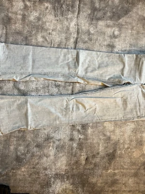 Ljusgrå bootcut jeans Gina Tricot - Säljer ett par ljusgrå boitcut jeans från Gina Tricot med dubbla silverknappar och klassisk femficksmodell.  Lågmidjade. Jeansen är från barnavdelningen men passar någon som vanligtvis bär 36 och är runt 167