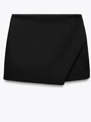 Svart omlott kjol - Stilren svart kjol med omlottdesign framtill och shorts baktill. Klassisk och enkel modell som passar till många olika looks. Tillverkad i ett mjukt tyg som ger en snygg passform och bekväm känsla. Perfekt för dig som vill ha kjol-looken men ändå känna dig bekväm. Storlek S!