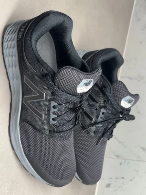  New Balance Fresh Foam sneakers - Helt Nya, Oanvät, Snygga svarta sneakers från New Balance med Fresh Foam-mellansula för extra komfort. Ovandelen är i meshmaterial som andas och har klassiska N-loggan på sidan. Skorna har svarta skosnören och en slitstark yttersula med hexagonmönster.