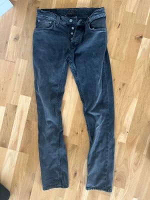 Svarta Nudie grim Tim - Säljer ett par svarta nudie grimtimjeans . Jeansen har diskreta sömmar och Nudie-logga på bakfickan. Tillverkade i mjuk denim som ger en snygg tvättad look. I väldigt bra skick