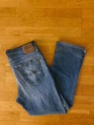 Blå Levi`s 567  - Säljer ett par klassiska blå jeans från Levi's Signature med bootcut-modell. Jeansen har en snygg tvättad look, fem fickor och läderpatch bak i midjan. Perfekta till vardagsstilen och tillverkade i slitstark denim.