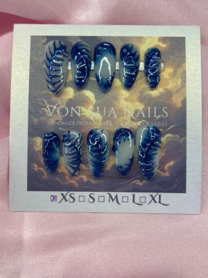 BlueFlow (XS);Medium Almond - Unika handgjorda press-on naglar i blått med vit bas och deep blue abstrakt 3D handmålade mönster. Naglarna har en medium längd och är almondform och en glansig finish som ger en cool och edgy look. Perfekt för dig som vill sticka ut med dina naglar.XS: 14 mm, 11 mm, 11,5 mm, 10 mm, 8 mm 