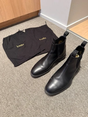 Loake Chatsworth Chelsea boot (2 påsar tillkommer) - Svarta Chelsea boots från Loake i kalvskinn. Nypris 4600 kr. Knappt använda. Perfekta för vår, höst eller vinter. En påse för varje sko tillkommer också för att hålla i bra skick. Kan tänka mig sänka mycket för bra och snabb affär!!!