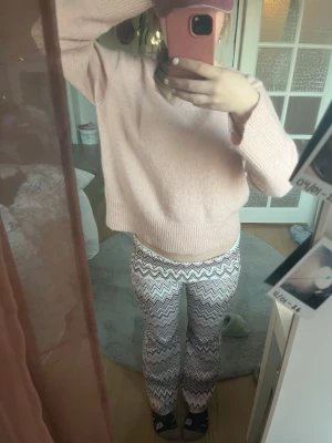 Mjukisbyxor med zigzag-mönster - Säljer ett par flaredbyxor med ett snyggt zigzag-mönster i brunt, vitt och ljusrosa. Byxorna är tillverkade i ett mjukt, fodrat och stretchigt material som är superbekvämt. Har använt ett ett par gånger😁