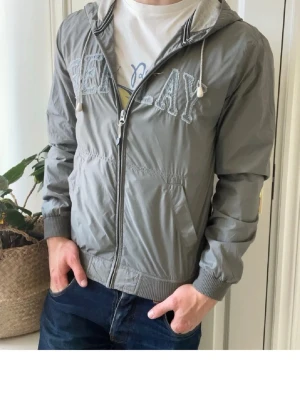 Replay Jacka - Sällsynt vintage replay jacka. Det är en windbreaker me luva o snören med fickor på vardera sida. Skicket är som nytt!!!! Skriv för mer information