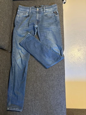 Blå slim fit jeans från Replay - Snygga blå slim fit jeans från Replay med klassisk femficksdesign. Jeansen har normal midja, dragkedjegylf och tydliga kontrastsömmar. Perfekta för en trendig och avslappnad look. Inga defekter och priset går att diskutera, säljer byxorna då det är försmå för mig! 33/34