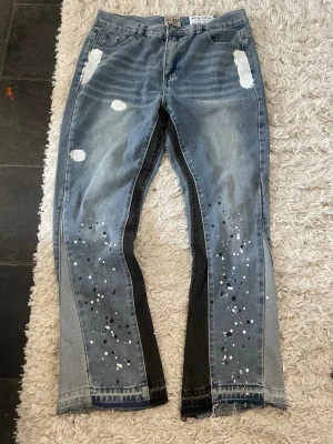 Galleri Dept jeans  - Säljer ett par blå jeans med coola färgstänk och slitna detaljer. Säljer dem pga att de är för stora för min son 
