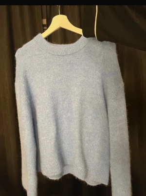 Ljusblå stickad tröja Gina Tricot - Blå stickad tröja från Gina tricot. Aldrig använd. Perfekt på sommaren att matcha till något vitt en sommarkväll tex. 