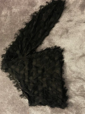 Snygg svart blus med fransar - Svart onesholder blus med snygga fransar . Från Gina tricot