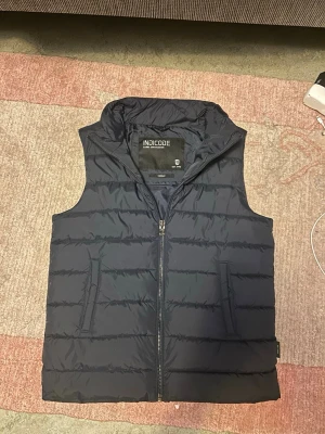Indicode väst - Säljer denna snygga mörkblåa indicode vest i storlek M, riktigt snygg och stilig vest, köpt på Zalando, ny pris på denna var 599kr kvitto finns.