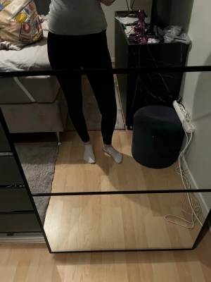 Svarta leggings med medel midja - Säljer ett par svarta leggings med medel midja och tight passform. De är stretchiga och sitter skönt mot kroppen, perfekta till både oversized tröjor och crop tops. Materialet är mjukt och följsamt, vilket gör dem riktigt bekväma att bära hela dagen.