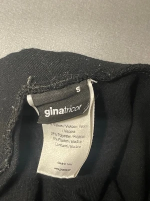 Svarta leggings från Gina Tricot - Svarta leggings från Gina Tricot i mjukt material med hög midja. Tillverkade av 67% viskos, 28% polyester och 5% elastan för en skön och stretchig passform. Perfekta att matcha med oversized tröjor eller hoodies.