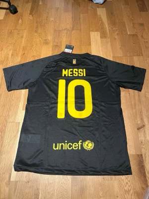 Barcelona 2011/12 away kit Messi #10 - Säljer en svart FC Barcelona matchtröja från Nike med Messi 10 på ryggen. Tröjan har gula detaljer, klubbmärke och Qatar Foundation-logga framtill samt UNICEF-logga bak. Tillverkad i Dri-FIT material som andas, perfekt för fotbollsträning.