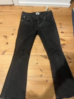 Svarta bootcut jeans från H&M - Snygga svarta bootcut jeans  med klassisk femficksdesign och låg midja. Jeansen har utsvängda ben och är tillverkade i ett mjukt denimtyg som ger en skön passform. 