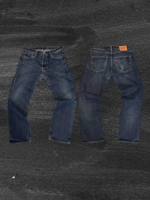 Feta Levi's 501  - Klassiska blå Levi's 501 jeans med rak passform och fem fickor. Jeansen har knappgylf och tydliga sömmar, tillverkade i slitstark denim. Perfekta för en avslappnad och tidlös stil.