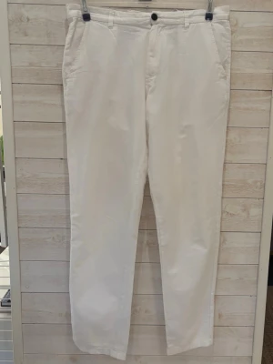 Vita linnebyxor från jack&jones - Snygga vita linnebyxor med raka ben och klassisk passform. Byxorna har sidfickor fram, två bakfickor med knappar och hällor för skärp. Perfekta för en fräsch och stilren look. Materialet är lätt och luftigt linne.