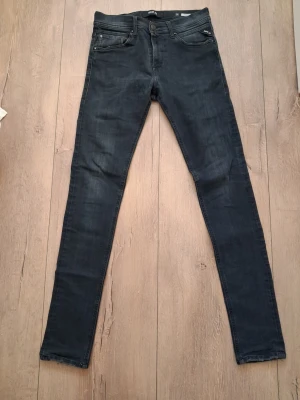  Svarta replay jeans  - Snygga svarta jeans från Replay med klassisk femficksdesign och dragkedjegylf. Jeansen har en smal passform och är tillverkade i stretchigt denimtyg för extra komfort. Perfekta för en trendig och avslappnad look.                                          W30 L34