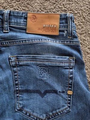 Diesel thavar D-N-A line - These Diesel Thavar Jeans from Diesel’s DNA 1978 line are a standout archival piece, blending modern slim-fit tailoring with the brand’s heritage roots. The Thavar model is known for the premium denim construction , really nice pair overall .                                                      ❗️size W32 and length around  L32❗️,Items from this line are often priced higher than standard releases (ranges from $270 to $350+) because of the labor-intensive treatments involved.