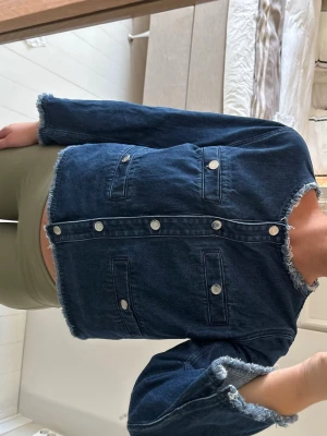 Mörkblå jeansjacka - Mörkblå croppad jeansjacka från Arket. Jackan har fyra fickor framtill och silverfärgade knappar. Jackan är i storlek 40, men väldigt liten i storleken och passar mig som normalt har storlek 36😇