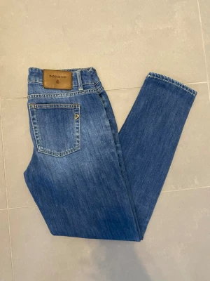 Dondup Jeans blåa  - Hej säljer ett par snygga dondup jeans i en blå färg med snygga fades det är i storlek 30 och är bra skick det ända är ett litet hål vi gylfen som går att sy annars syns det knappt när man har dom på bra skick 