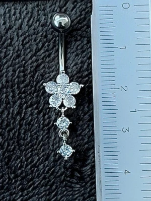 NY oanvänd Navelpiercing med hänge | Kirurgiskt stål | Blomma och vita stenar  - 💕30% Bundle-rabatt vid köp av minst 2 artiklar. ⭐️NY oanvänd piercing i kirurgiskt stål; rostfritt och säkert för läkta piercingar.                               📏MÅTT ⭕️Stavens längd: 10mm ⭕️Stavens tjocklek: 1,6mm ⭕️Smyckets totala längd: 35mm                                                                         🤍Färger: Silver och vit                                                            💌Skickas spårbart via Plick SafePay.