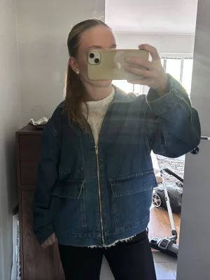 Oversized blå jeansjacka - Säljer en blå jeansjacka från HM med dragkedja framtill och stora fickor på sidorna. 