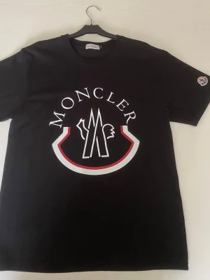 Svart Moncler t-shirt - En svart Moncler t-shirt i nytt skick för ett mycket bra pris.