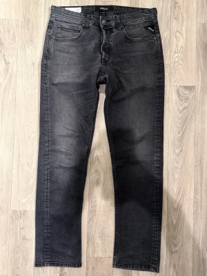 Replay Grover Jeans Mörkgrå W33/L30 - Straight Fit - Replay Grover mörkgrå jeans med straight fit passform som sitter rakare och bekvämt med normal midja och funkar till allt, storlek W33/L30, midja 41 cm, ytterbenslängd 101 cm, benöppning 18 cm, modellen är 185cm & väger 65kg, i fint skick.