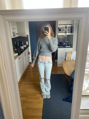 Ljusblå slitna jeans med hål - Säljer en grå croppad stickad tröja med långa ärmar och tight passform längst ner på nåder ärmar och mage. Materialet känns mjukt och mysigt, perfekt för kyligare dagar. Säljer då jag inte tycker den passar mig i stil. Frakt ingår knte i priset. Annvänd 1 gång av mig men fick av en kompis..en tunn tröja.