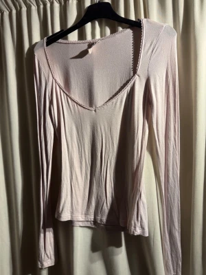 Ljusrosa långärmad topp från Nelly - Söt ljusrosa långärmad topp med v-ringning och fin spetskant runt halsen. Enkel och stilren design som passar till mycket. Sparsamt använd