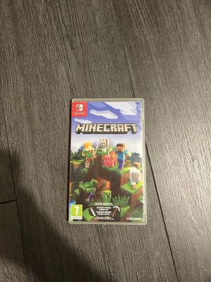 Minecraft till Nintendo Switch - Minecraft till Nintendo Switch i plastfodral. Omslaget är färgglatt med pixelgrafik och visar flera karaktärer och varelser från spelet. Perfekt för dig som gillar att bygga, utforska och överleva i en öppen värld. Spelet är klassat från 7 år.