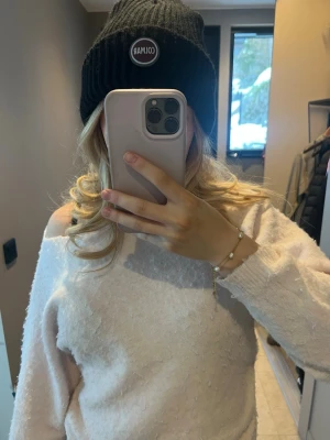 Svart ribbad mössa från Colmar - Säljer en svart ribbstickad mössa från Colmar med uppvikt kant och rund logotyp framtill. Klassisk och enkel design som passar till det mesta. Perfekt för kalla dagar och snygg till både jacka och hoodie.