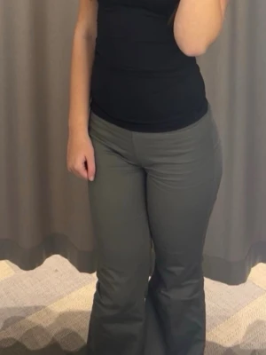 Grå bootcut byxor i bomull - Snygga grå bootcut byxor i mjukt bomullsmaterial. Byxorna har en klassisk passform med utsvängda ben och midja som sitter bekvämt. Perfekta för dig som vill ha en stilren och enkel look.