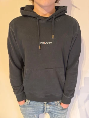 Saint Laurent Hoodie - | Skick: 10/10 | Färg: Svart | Modell: 174cm 64kg | Vad inkluderas: Enbart hoodien | Nypris: 7 000kr - 11 000kr | 