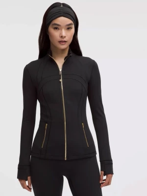 define jacket/träningsjacka från Lululemon - Snygg svart träningsjacka från Lululemon med guldfärgade dragkedjor och figurnära passform. Jackan har långa ärmar med tumhål och två fickor framtill. Tillverkad i stretchigt funktionsmaterial som passar perfekt till träning eller som ett sportigt lager. i storlek 2/xs