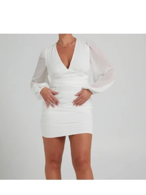 Vit kort omlottklänning med v-ringning - Perfekta studentklänningen, bachelorette party eller white party!   Bandet runt klänningen kan knytas både fram för en rosett eller bak för att accentuera midjan.  Kontakta mig för bilder på hur den ser ut på modellen!   Klänningen är endast testad och aldrig använd     #vitklänning #miniklänning #vneck #deepv #puffärm #ballongsleeve #sheer #romantisk #teminin #sommarklänning #festklänning #studentklänning #graduation #brunchoutfit #datenight #softgirl #coquette #elegant #chic #trend #ruched #kn