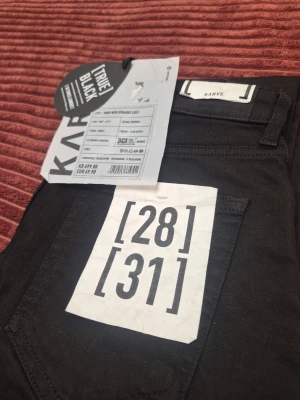 Svarta jeans från Karve, storlek 28/31 - Snygga svarta jeans från Karve i modellen True Black. Klassisk femficksdesign med raka ben och normal midja. Jeansen är tillverkade i ett mjukt och stretchigt material för extra komfort. Perfekta för dig som gillar en clean och stilren look.
