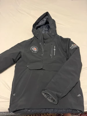 Svart vindjacka Sail Racing med huva, magficka - Svart vindjacka Sail Racing med huva, magficka