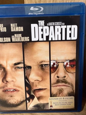 The Departed Blu-ray film - Säljer Blu-ray-utgåva av filmen The Departed, regisserad av Martin Scorsese. Omslaget är blått och visar huvudrollsinnehavarna. Filmen är på engelska med svensk text och innehåller extramaterial. Perfekt för filmälskare som vill ha en spännande thriller i samlingen.
