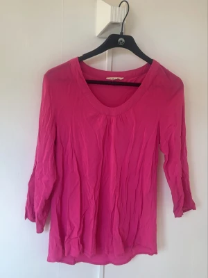 Rosa topp med trekvartsärm - En enkel och snygg rosa topp med trekvartsärm och v-ringning. Toppen är i ett lätt och mjukt material, perfekt för vår och sommar. Passar till både jeans och kjol för en avslappnad look. Från 365
